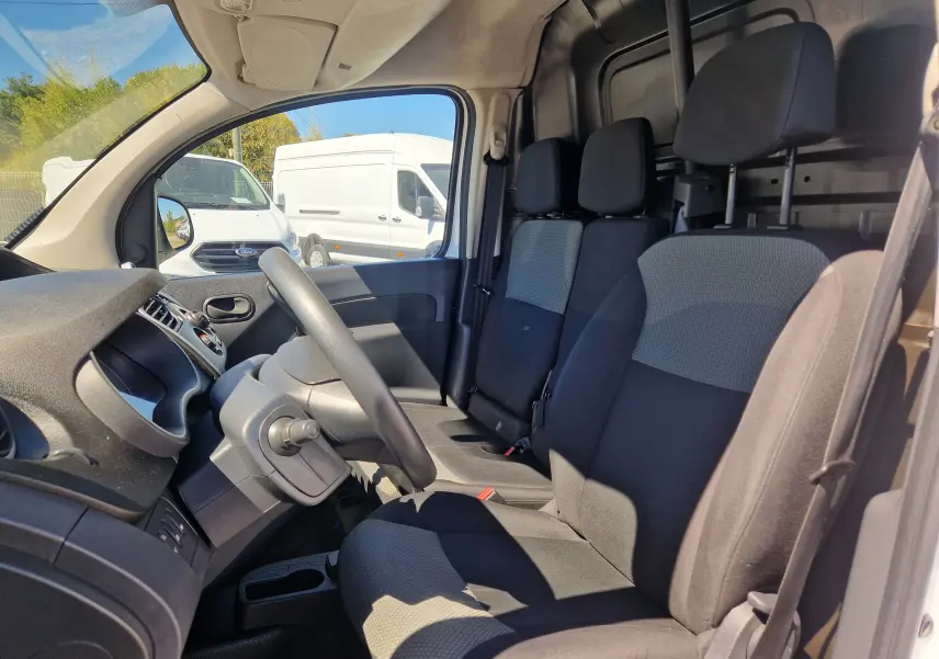 Vue intérieure centrée sur le volant noir du Renault Kangoo blanc 2021 avec tableau de bord et commandes visibles.
