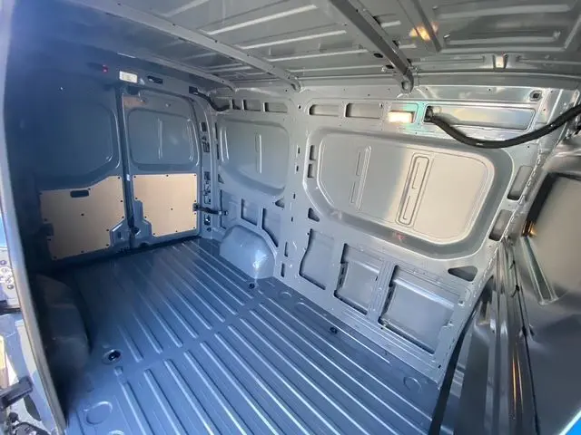 Vue arrière ouverte du Renault Master gris urbain 2025 montrant l'espace de chargement tôlé et le plancher métallique.