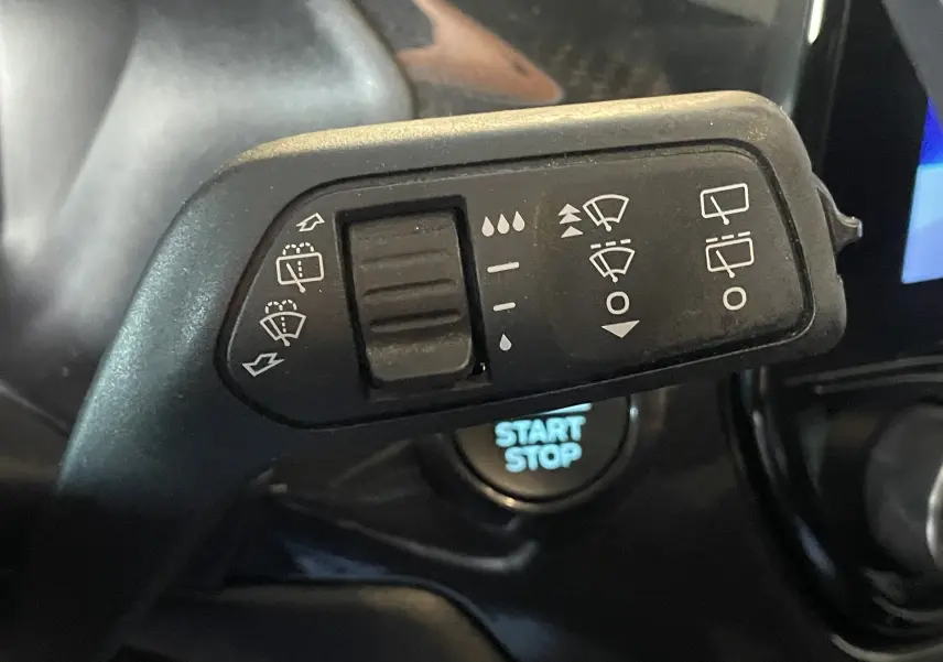 Gros plan sur la commande d'essuie-glace du Ford Puma gris 2020, avec bouton Start/Stop en arrière-plan.