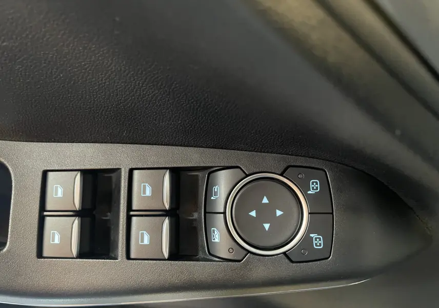 Commandes électriques des vitres et réglages des rétroviseurs côté gauche dans une Ford Puma gris 2020.