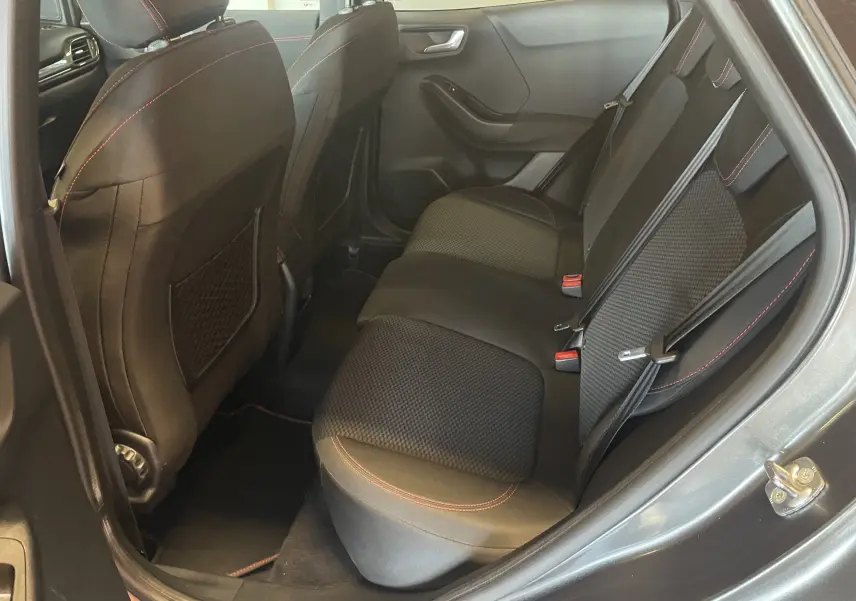 Vue intérieure arrière côté droit du Ford Puma gris 2020, sièges tissu noir avec surpiqûres rouges et ceintures grises.