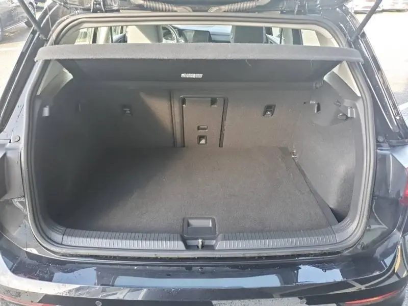 Coffre ouvert vue arrière d’une Volkswagen Golf 1.5 eTSI noire intense nacrée, espace de chargement vide et propre.