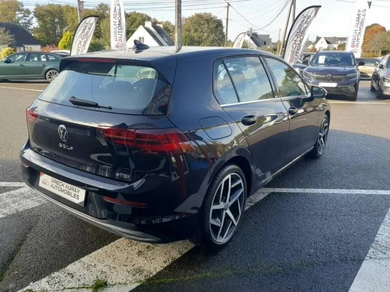 Vue 3/4 arrière droite d'une Volkswagen Golf noire intense nacrée avec jantes 18 pouces en aluminium.