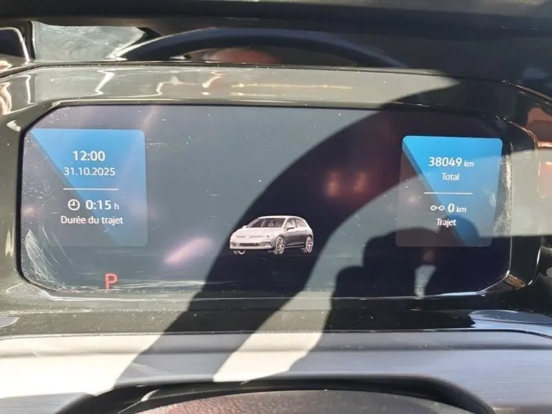 Affichage numérique du tableau de bord de la Volkswagen Golf 1.5 eTSI, montrant un véhicule blanc en vue de face.