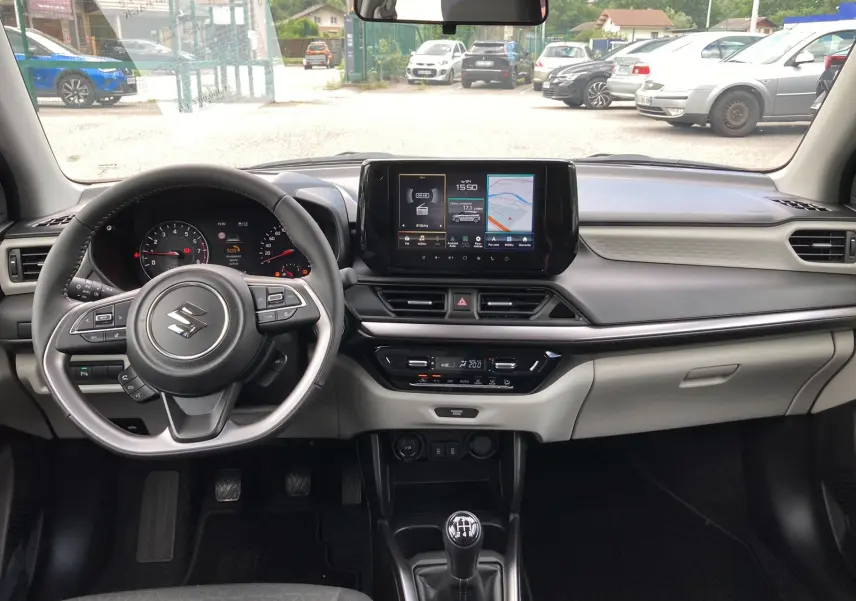 Intérieur moderne de Suzuki Swift 2025, vue frontale du tableau de bord avec écran tactile et volant multifonctions cuir.