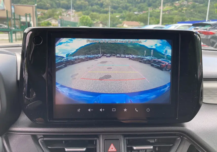Écran central affichant la caméra de recul d'une Suzuki Swift 2025 bleu Frontier Pearl, vue depuis l'habitacle.