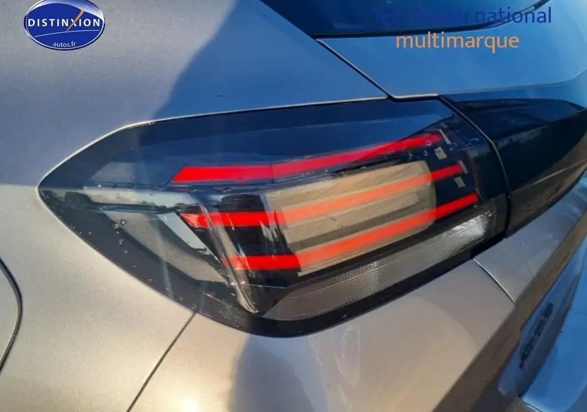 Gros plan sur le feu arrière droit rouge et noir d'une Peugeot 208 1.2 100 Allure gris Artense, vue arrière partielle.