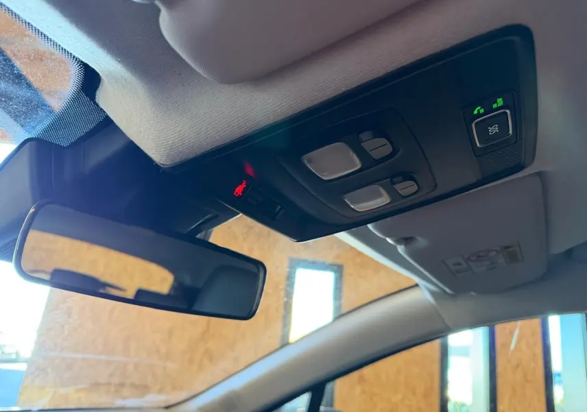 Vue intérieure du plafonnier et du rétroviseur d’une Renault Clio 2023, avec commandes d’éclairage et appel d’urgence.