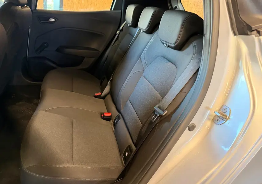 Vue intérieure côté droit sur la banquette arrière noire de la Renault Clio gris platine avec ceintures et appuie-têtes visibles.