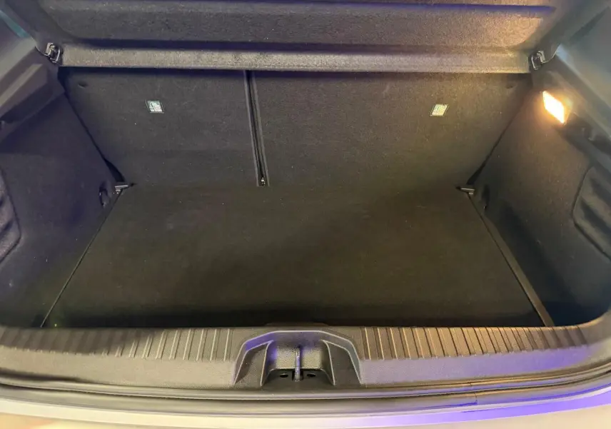 Coffre ouvert de la Renault Clio gris platine 2023, vue intérieure montrant un espace de rangement propre et éclairé.