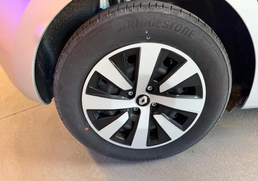 Gros plan sur la roue avant gauche gris platine d'une Renault Clio 2023 avec jante alliage bicolore et logo Renault central.