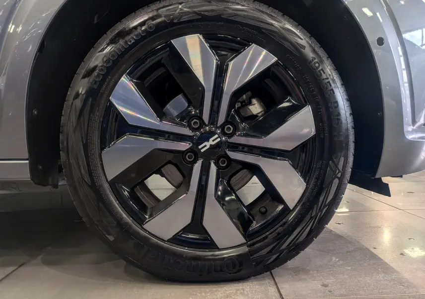 Gros plan sur la roue avant droite de la Dacia Sandero 2025 gris schiste, jante alliage bicolore distinctive.