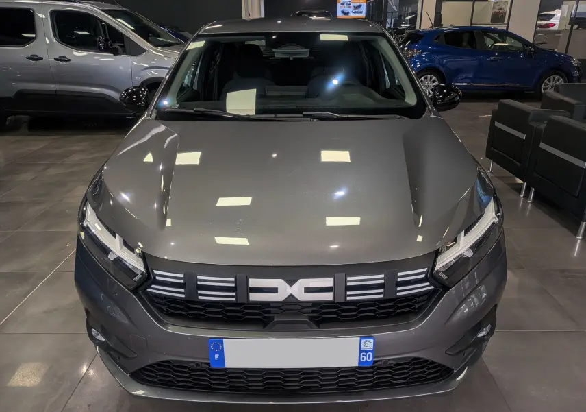 Vue avant d'une Dacia Sandero TCe 90 CH JOURNEY 2025 en gris schiste, avec calandre noire et phares LED allumés.