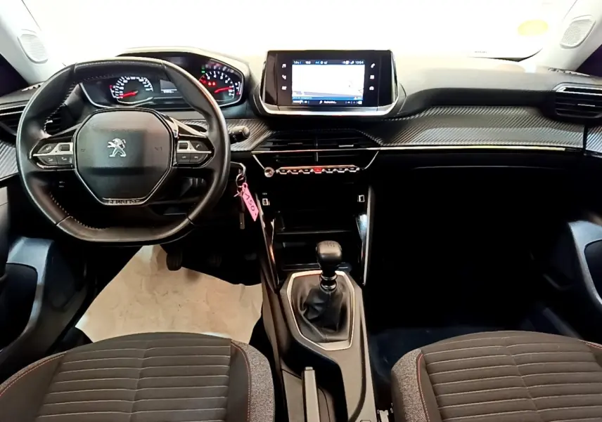 Vue intérieure avant du Peugeot 2008 2021, tableau de bord noir avec écran tactile et volant cuir multifonctions.