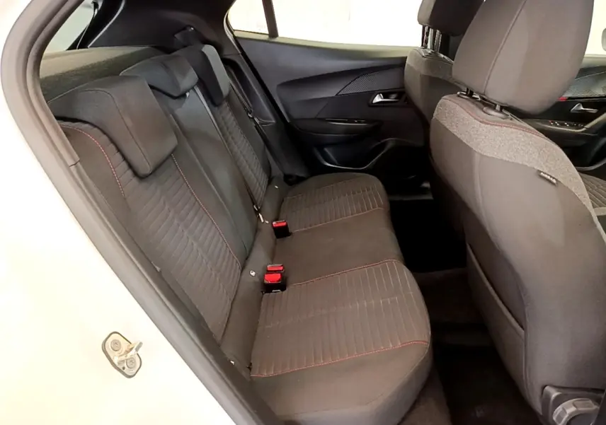 Vue intérieure côté gauche montrant la banquette arrière noire avec surpiqûres rouges du Peugeot 2008 blanc.