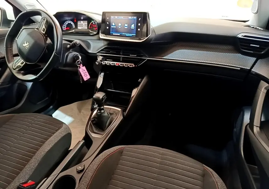 Vue intérieure avant droite du Peugeot 2008 2021, volant cuir multifonctions, écran tactile central et levier de vitesses manuel.
