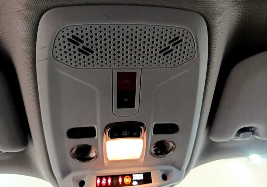 Vue intérieure du plafonnier avec éclairage et bouton SOS du Peugeot 2008 blanc, version BlueHDi 110 S&S Active Business.