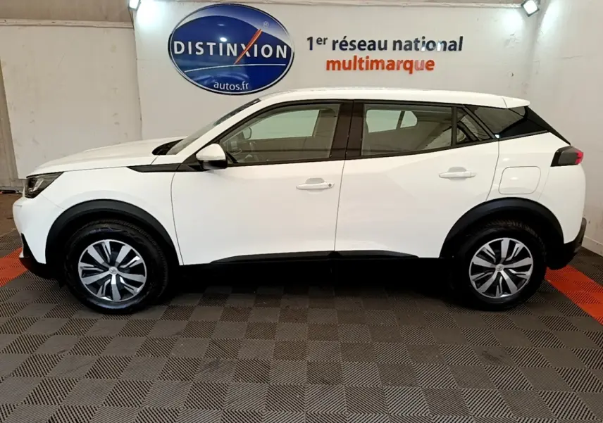 Peugeot 2008 blanc vue de profil côté gauche, avec jantes alliage et détails noirs contrastants.