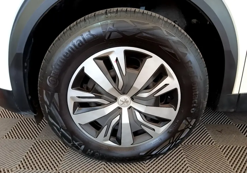 Gros plan sur la roue avant droite blanche d’un Peugeot 2008 2021 avec jante en alliage et pneu Continental.