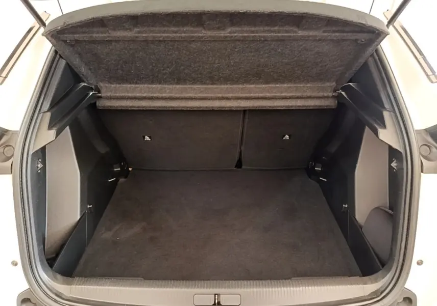Coffre ouvert vu de face d’un Peugeot 2008 blanc, montrant un espace de chargement propre et spacieux.
