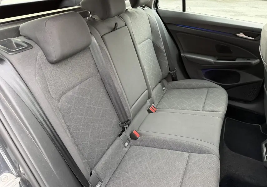 Vue intérieure côté droit de la banquette arrière grise en tissu de la Volkswagen Golf SW 2022 avec accoudoir central rabattable.