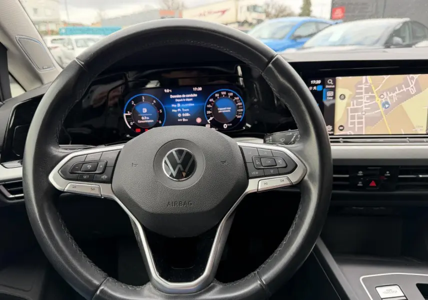 Vue rapprochée du volant multifonction noir et du tableau de bord digital de la Volkswagen Golf SW gris 2022.