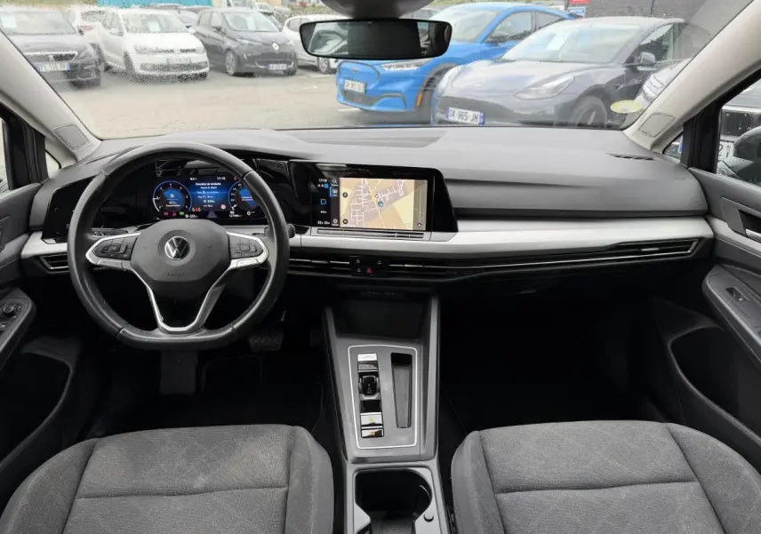 Vue intérieure avant de la Volkswagen Golf SW 2.0 TDI gris, avec tableau de bord digital et écran tactile central.