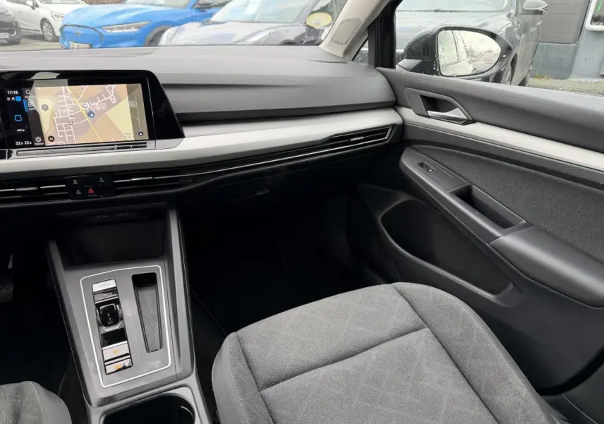 Vue intérieure côté passager avant de la Volkswagen Golf SW 2.0 TDI gris, avec tableau de bord et écran tactile visible.