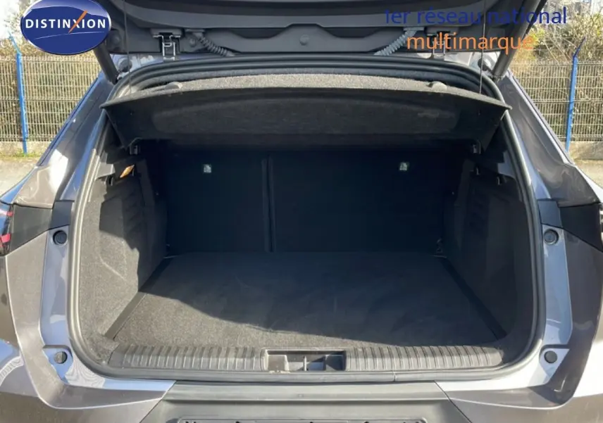 Coffre ouvert vu de l’arrière d’une Renault Symbioz gris cassiopée métal, montrant l’espace de chargement vide.