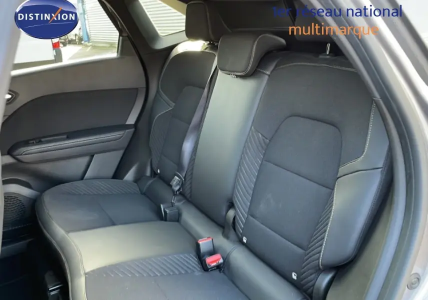 Vue intérieure montrant la banquette arrière en tissu et cuir noir du Renault Symbioz 2025, porte arrière ouverte.