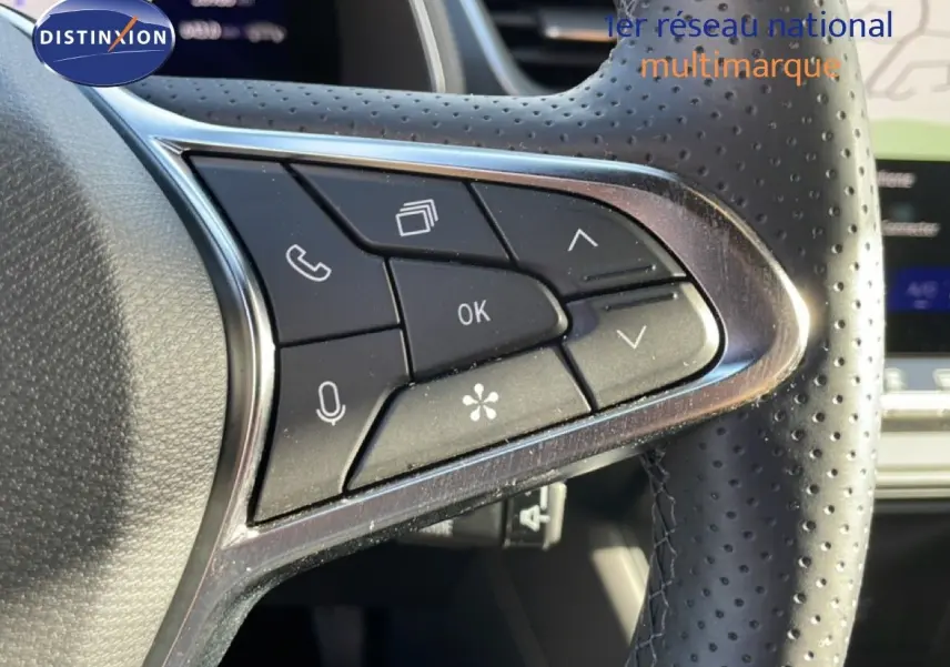 Gros plan sur les commandes multifonctions à gauche du volant en cuir perforé du Renault Symbioz gris cassiopée métal.