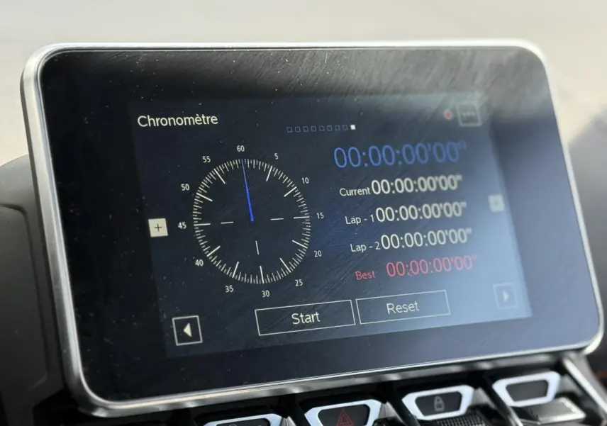 Écran tactile central de l'Alpine A110 1.8T 292 S affichant un chronomètre, intérieur sobre et moderne.