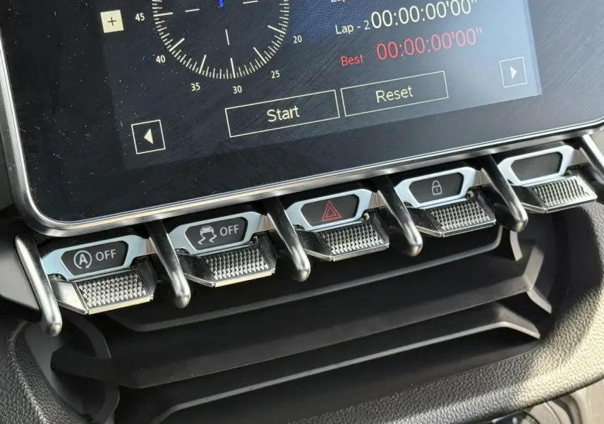 Gros plan sur les commandes en métal brossé sous l'écran tactile de l'Alpine A110 Gris Tonnerre Mat, version 2020.