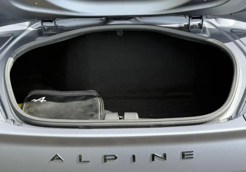 Coffre avant ouvert de l'Alpine A110 Gris Tonnerre Mat 2020, avec trousse noire marquée du logo Alpine.