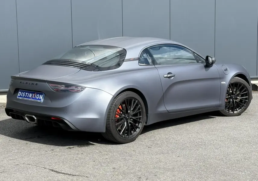 Vue 3/4 arrière droite de l'Alpine A110 1.8T 292 S gris Tonnerre mat avec jantes noires et étriers orange.