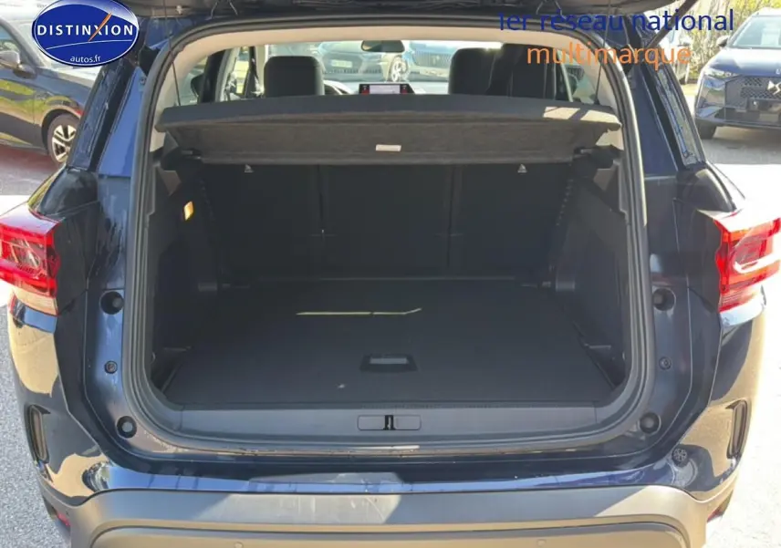Coffre ouvert vu de l'arrière d'un Citroën C5 Aircross bleu eclipse, montrant l'espace de chargement et la plage arrière.