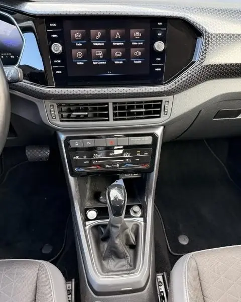 Vue plongeante sur la console centrale et l'écran tactile du Volkswagen T-Cross gris foncé 1.0 TSI R-Line Tech 2023.