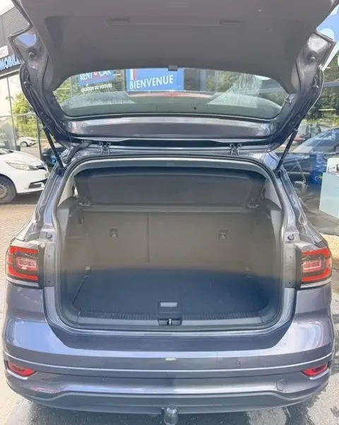 Vue arrière du Volkswagen T-Cross gris foncé 2023 avec coffre ouvert et hayon relevé, montrant l'espace de chargement vide.