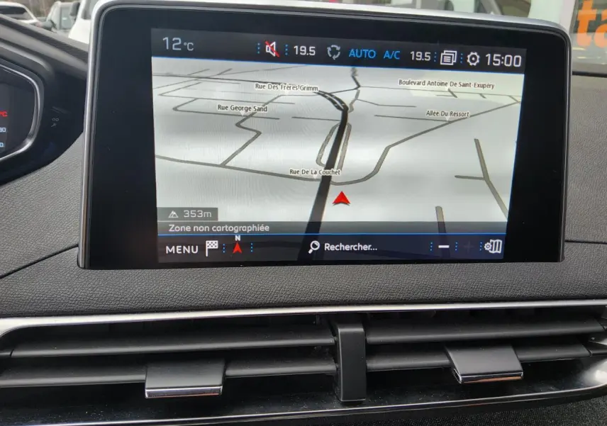 Écran tactile du système de navigation Peugeot i-Cockpit affichant une carte, tableau de bord noir.