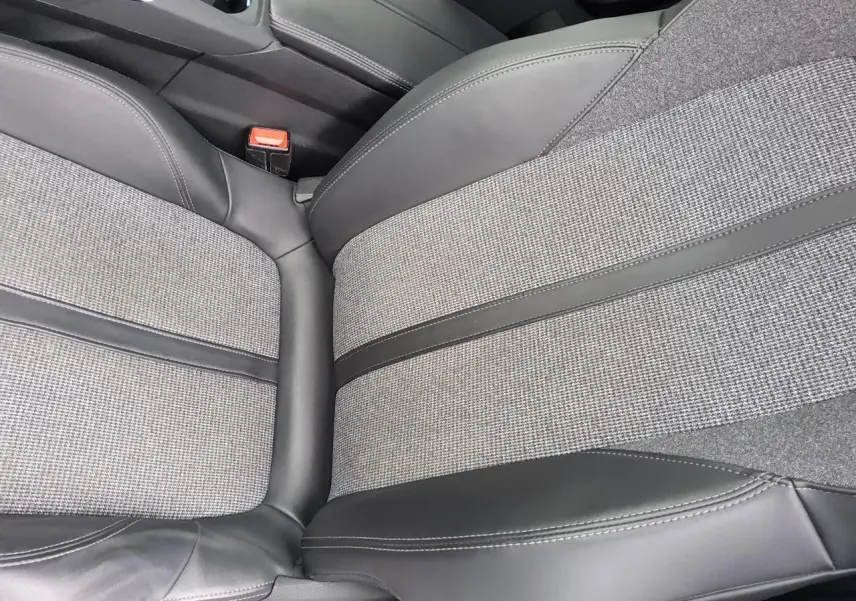 Gros plan sur la sellerie TEP et tissu gris à motifs du siège avant droit du Peugeot 3008 rouge foncé.