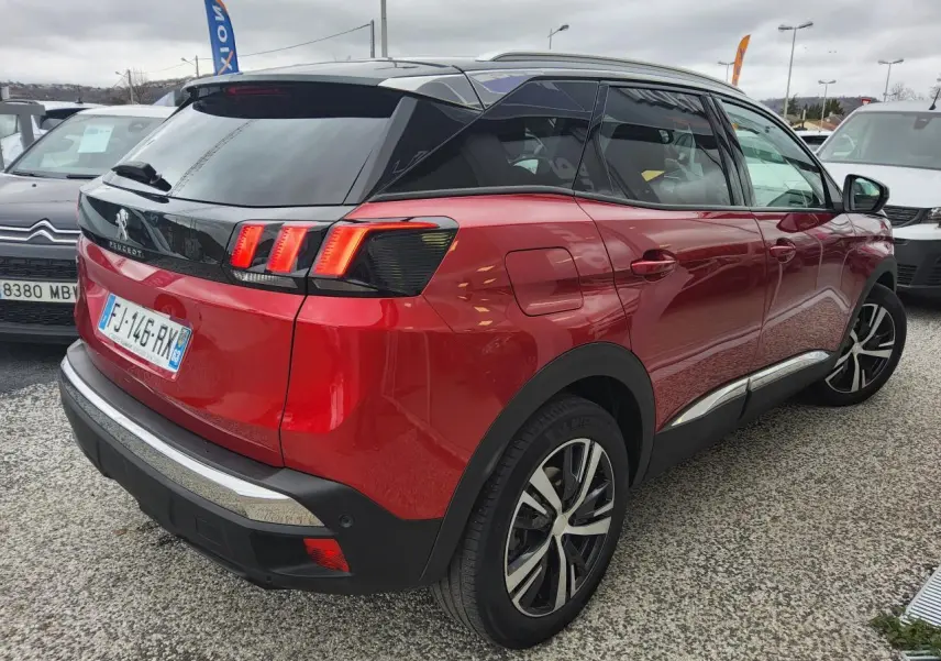 Vue 3/4 arrière droite du Peugeot 3008 rouge foncé avec toit noir et jantes alliage bi-ton diamantées.