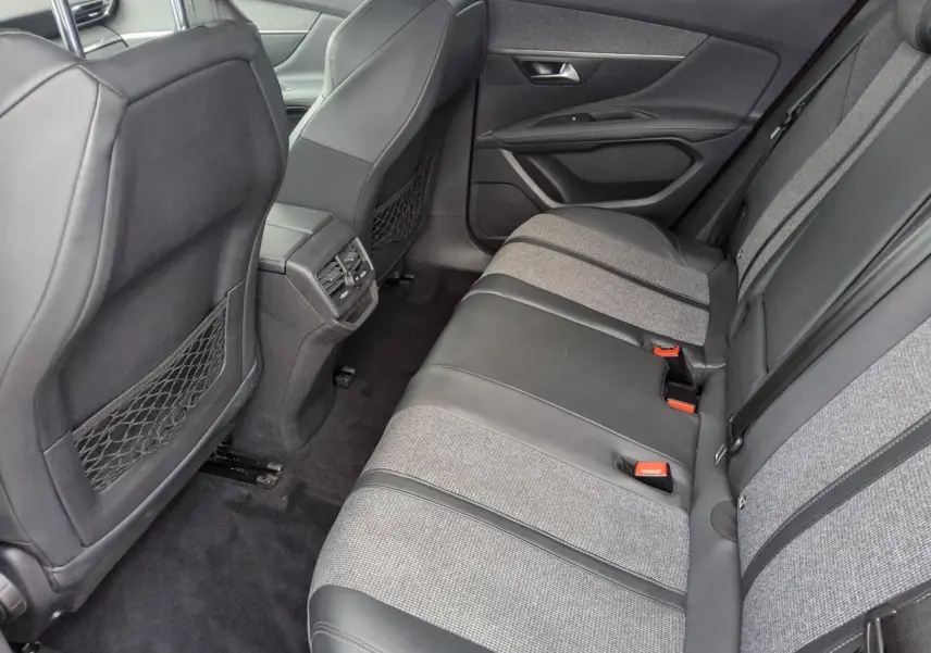Vue arrière côté droit de l’habitacle du Peugeot 3008 avec banquette bi-matière gris et noir et aérateurs centraux.