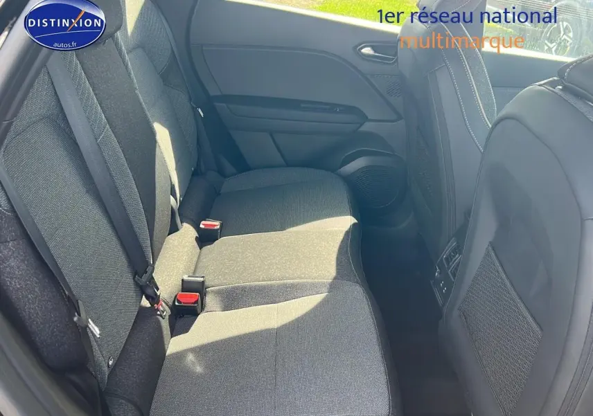 Vue intérieure montrant la banquette arrière grise du Renault Captur 2025 avec ceintures et filets de rangement sur les sièges avant.