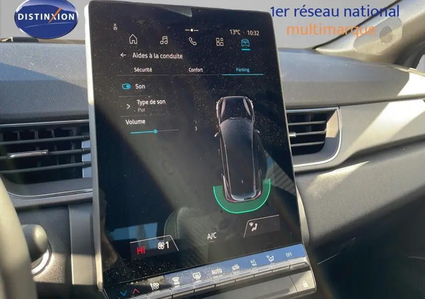 Écran tactile central du tableau de bord du Renault Captur E-Tech gris rafale, affichant les aides à la conduite et le parking assisté.