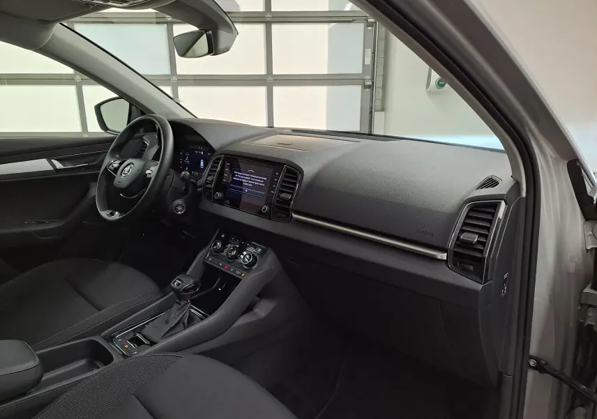 Vue intérieure côté conducteur du Skoda Karoq gris perle 2023, mettant en valeur le tableau de bord digital et la console centrale.