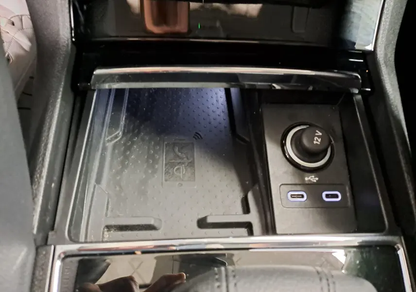 Gros plan sur la console centrale du Skoda Karoq 2023, montrant la phonebox à recharge par induction et prises USB-C.