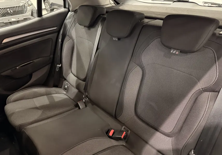 Vue intérieure des sièges arrière en tissu gris foncé de la Renault Mégane IV 1.5 dCi 115 Evolution, avec appuie-têtes et ceintures visibles.