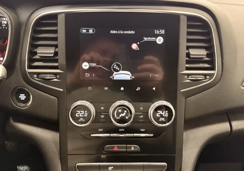 Tableau de bord de Renault Mégane IV gris Highland, vue centrale sur l'écran tactile et commandes de climatisation.