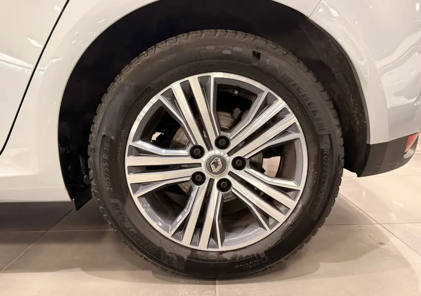 Gros plan sur la roue avant droite de la Renault Mégane IV gris Highland avec jante alliage à multiples branches.