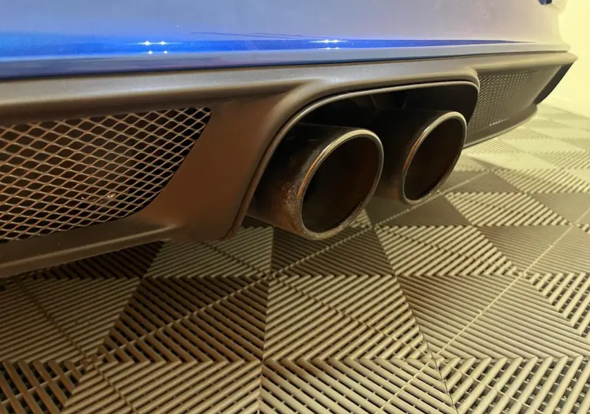 Gros plan sur la double sortie d’échappement arrière noire d’une Porsche 911 GT3 bleu saphir.